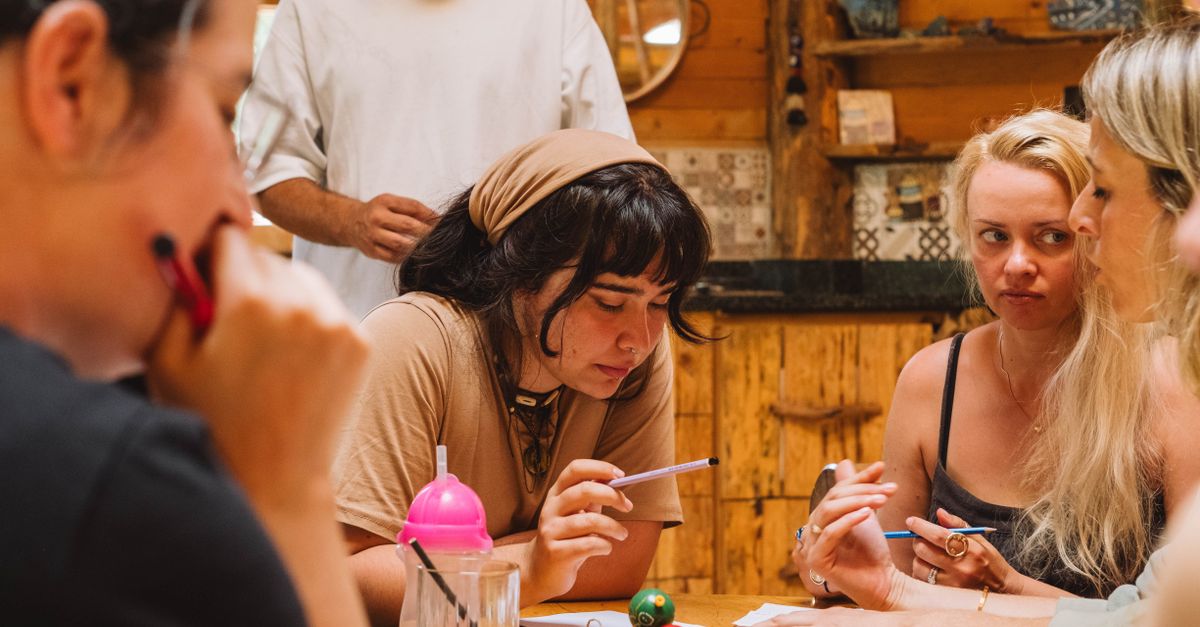Grupo de personas conversando alrededor de una mesa con libros abiertos